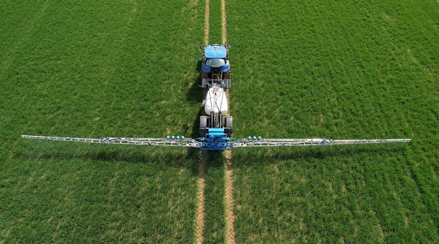 Système de pulvérisation intelligent CHCNAV SprayX100 sur un tracteur pulvérisateur dans un champ
